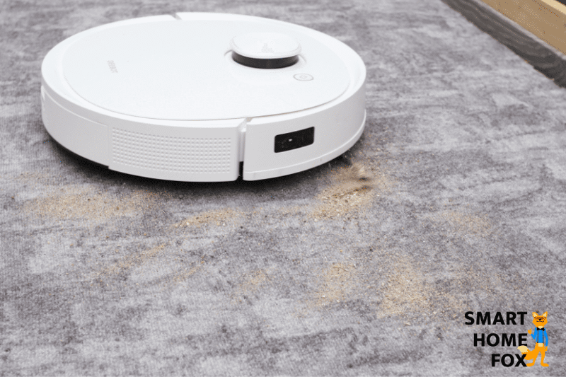 Ecovacs Deebot T9 reinigt Sand auf einem kurzflorigen Teppich